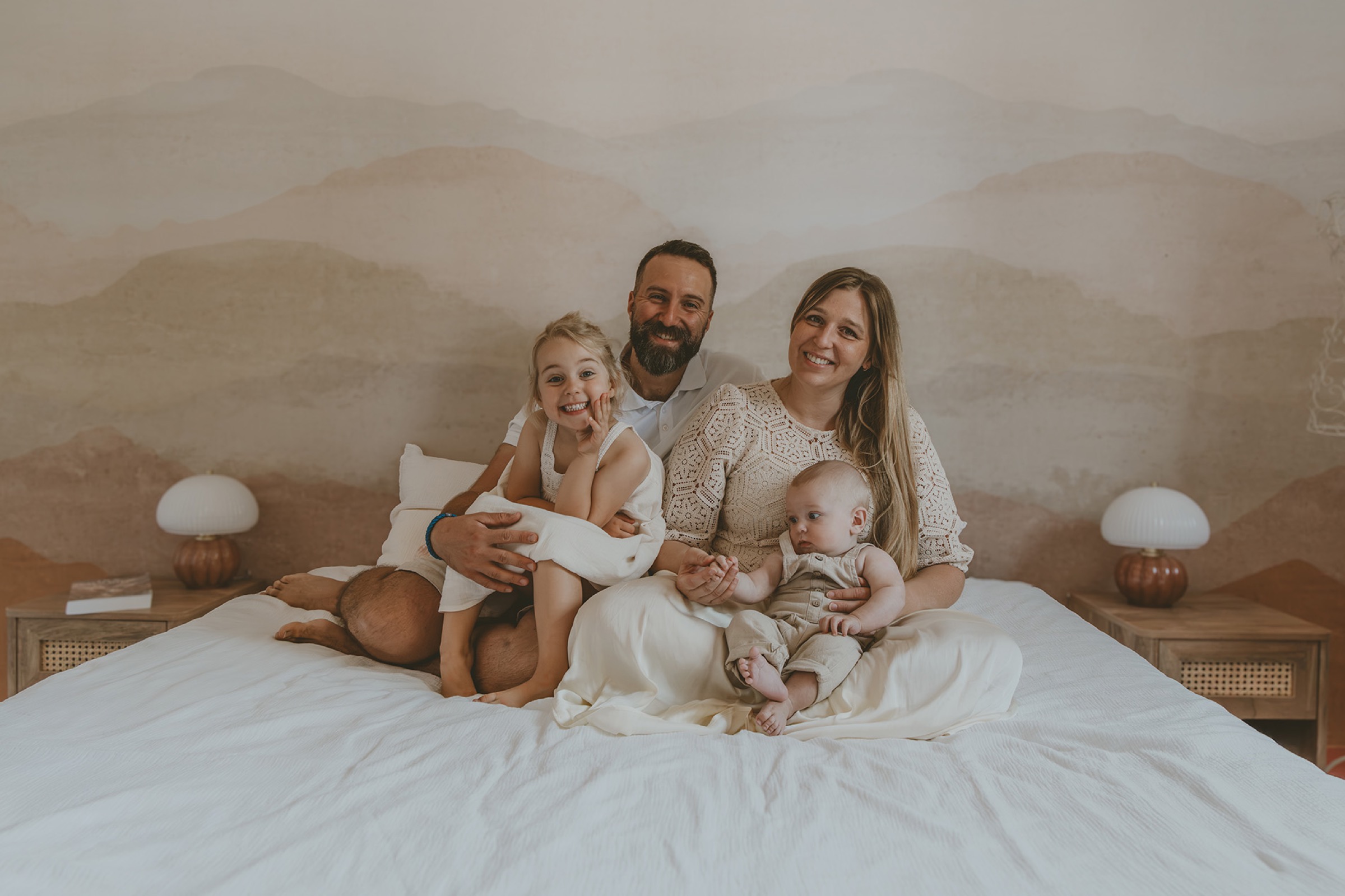 Famille de quatre sur le lit — séance photo de famille à la maison