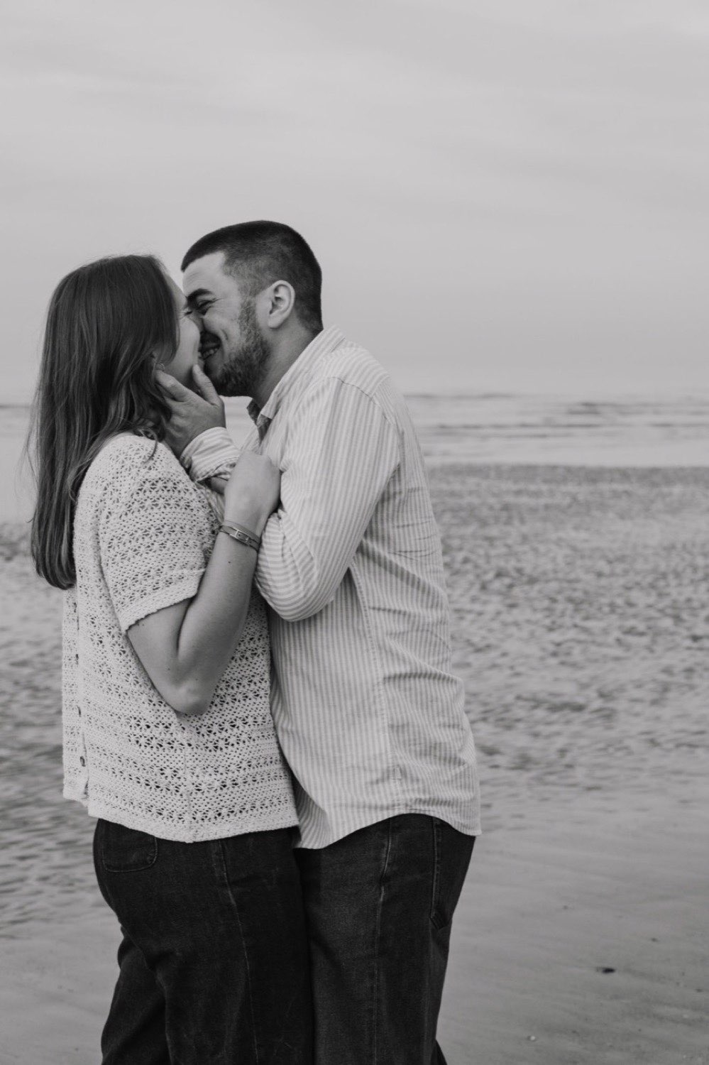 Un couple qui attend un enfant, enlacé, en noir et blanc