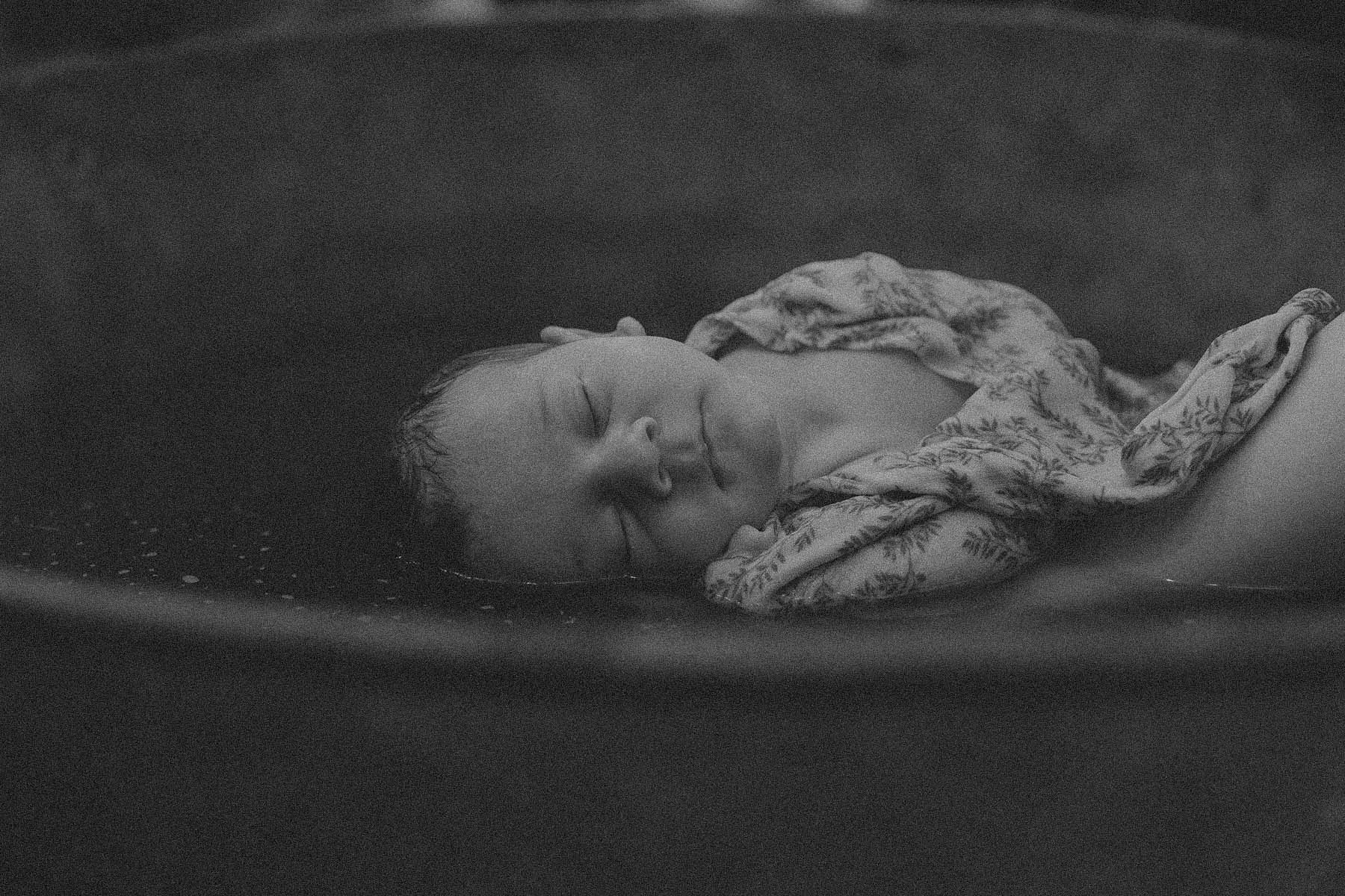 Séance photo de naissance — nouveau-né emmailloté, endormi